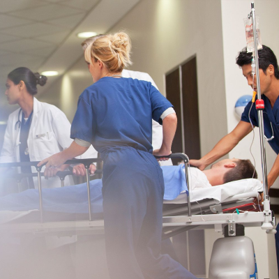 A group of clinicians transporting a patient on a hospital gurney