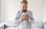 A man holding his chest in discomfort