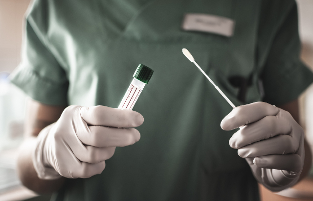 Nurse holds swab for coronavirus test.