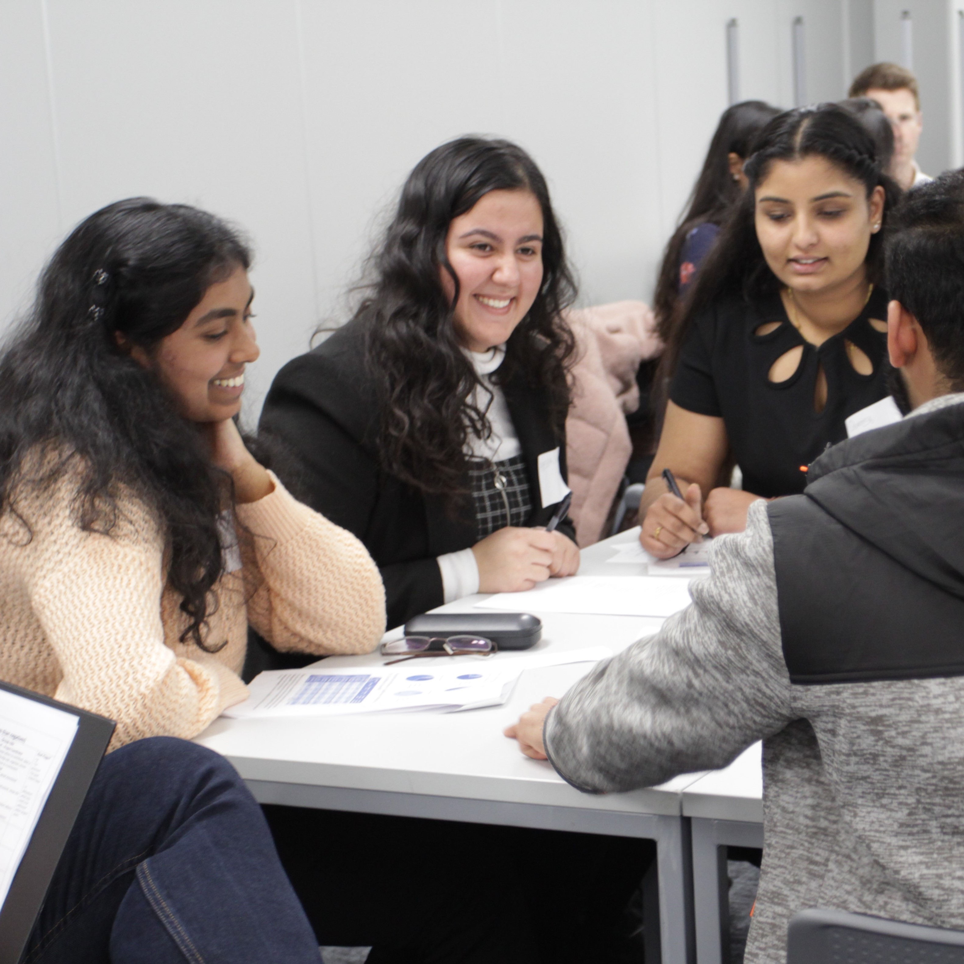 Students sat around desk and talking