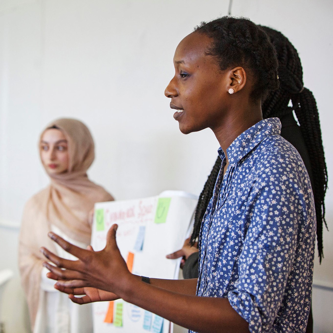Students presenting work on flipchart paper