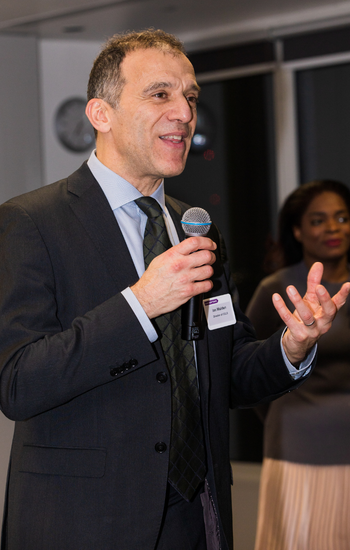 Ian Walden speaking into a microphone at an event.