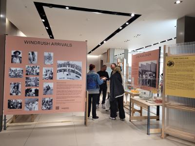 People walking around a gallery looking at work and information in the Dorcas Stories exhibition.