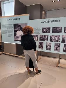 A person looking at an information board and photos of the Docar Stories exhibition.