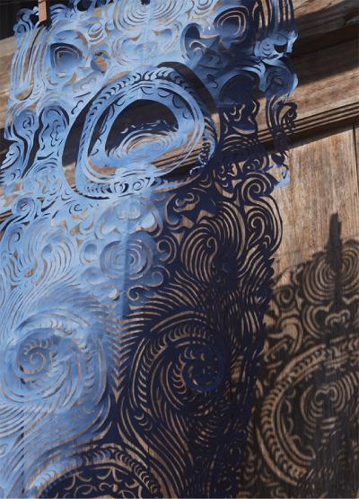 Example of Miao paper-cutting in blue. The pattern is circles and waves.