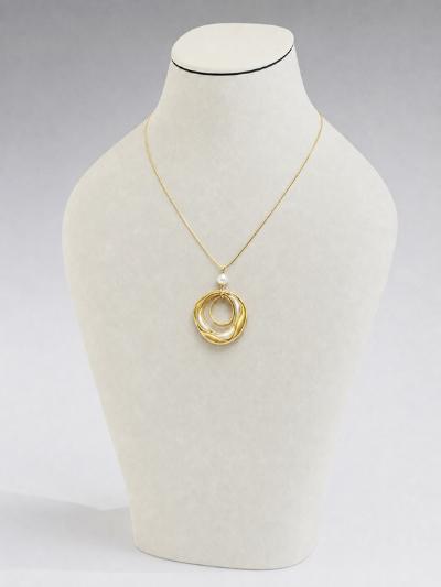 A gold necklace being displayed on a mannequin bust.