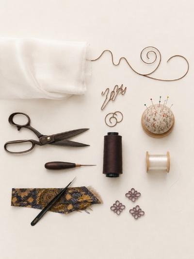 Scissors and jewellery making implements arranged on a table.