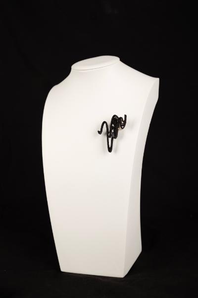 A black broach on a mannequin bust.