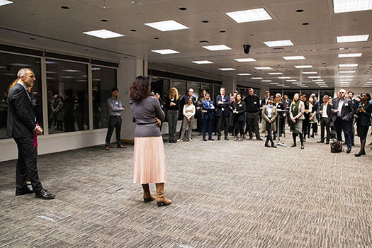 A person presenting to a group of CCLS students and alumni