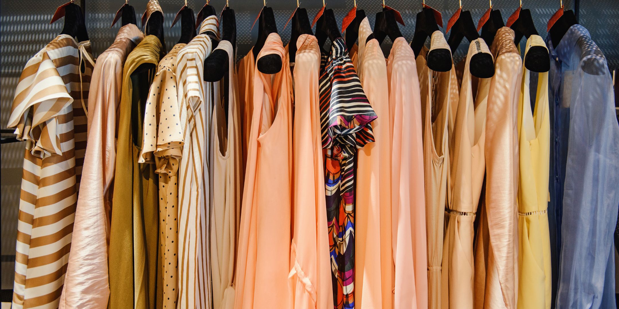 Items of clothing hung on hangers on a rail