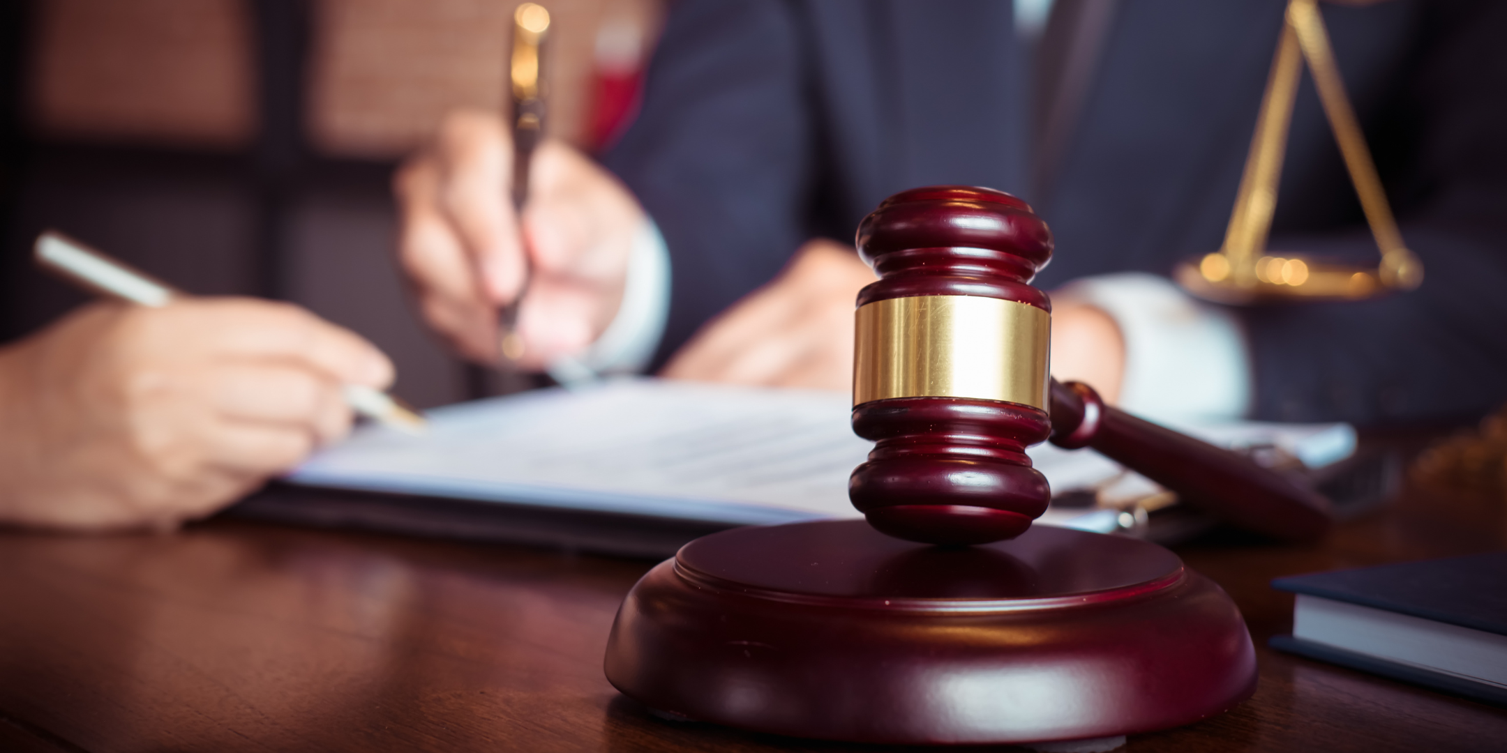 gavel and person writing on documents