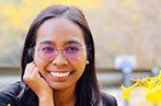 Nuanchan Changchit smiling, wearing glasses. Next to her is a yellow flower.