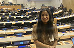 Professor Miriam Goldby in the chamber of UNCITRAL, with seats of different countries behind her.