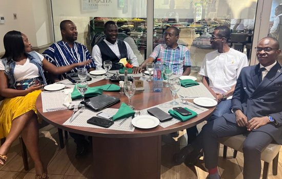 Six people sat at a round table in discussion