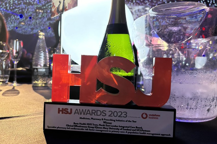 Photo of the physical award on a table, with glasses and party lights in the background