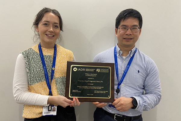 Harriet Larvin and Jianhua Wu holding the award