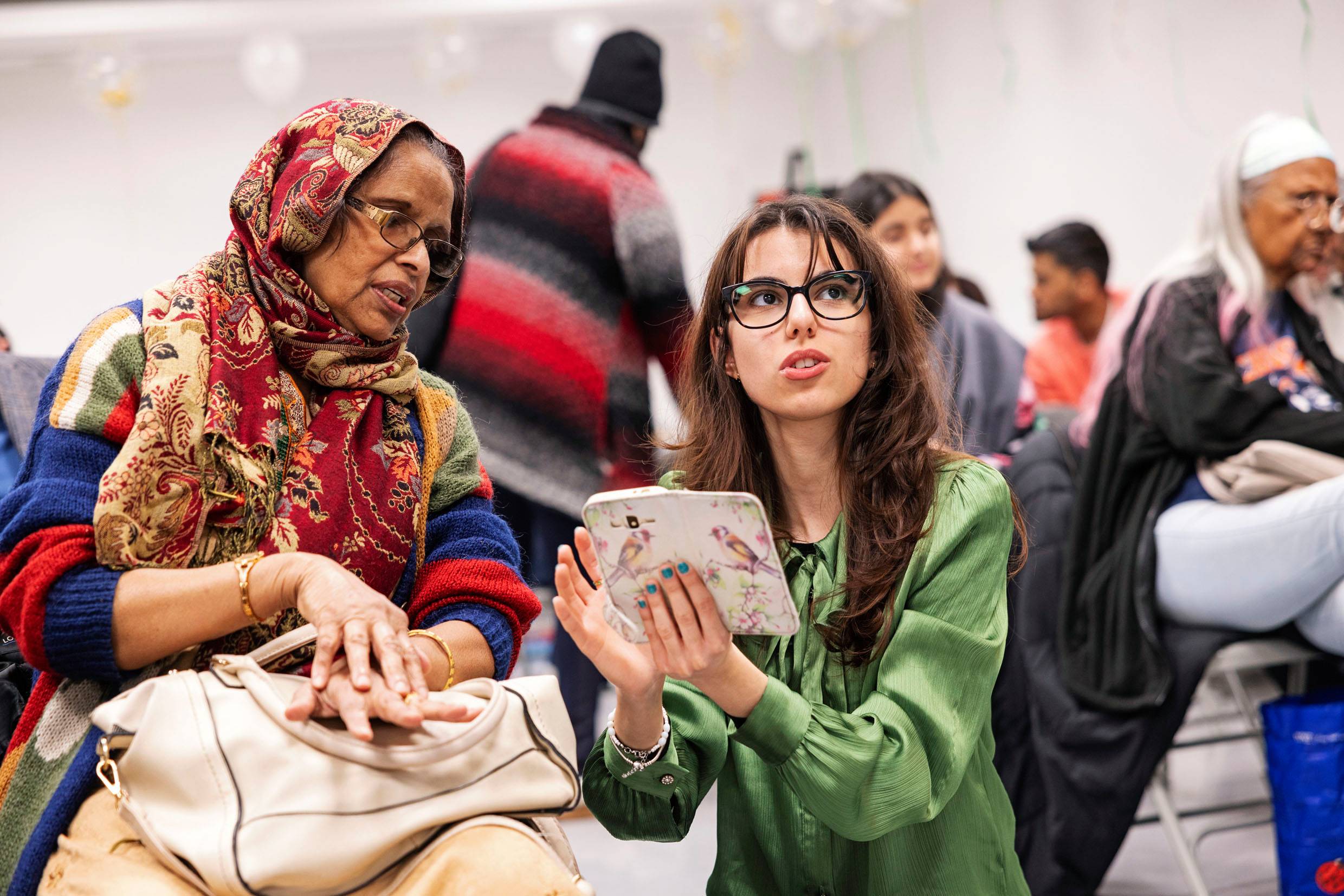 A student chats to an older lady at a Bengali community heritage event