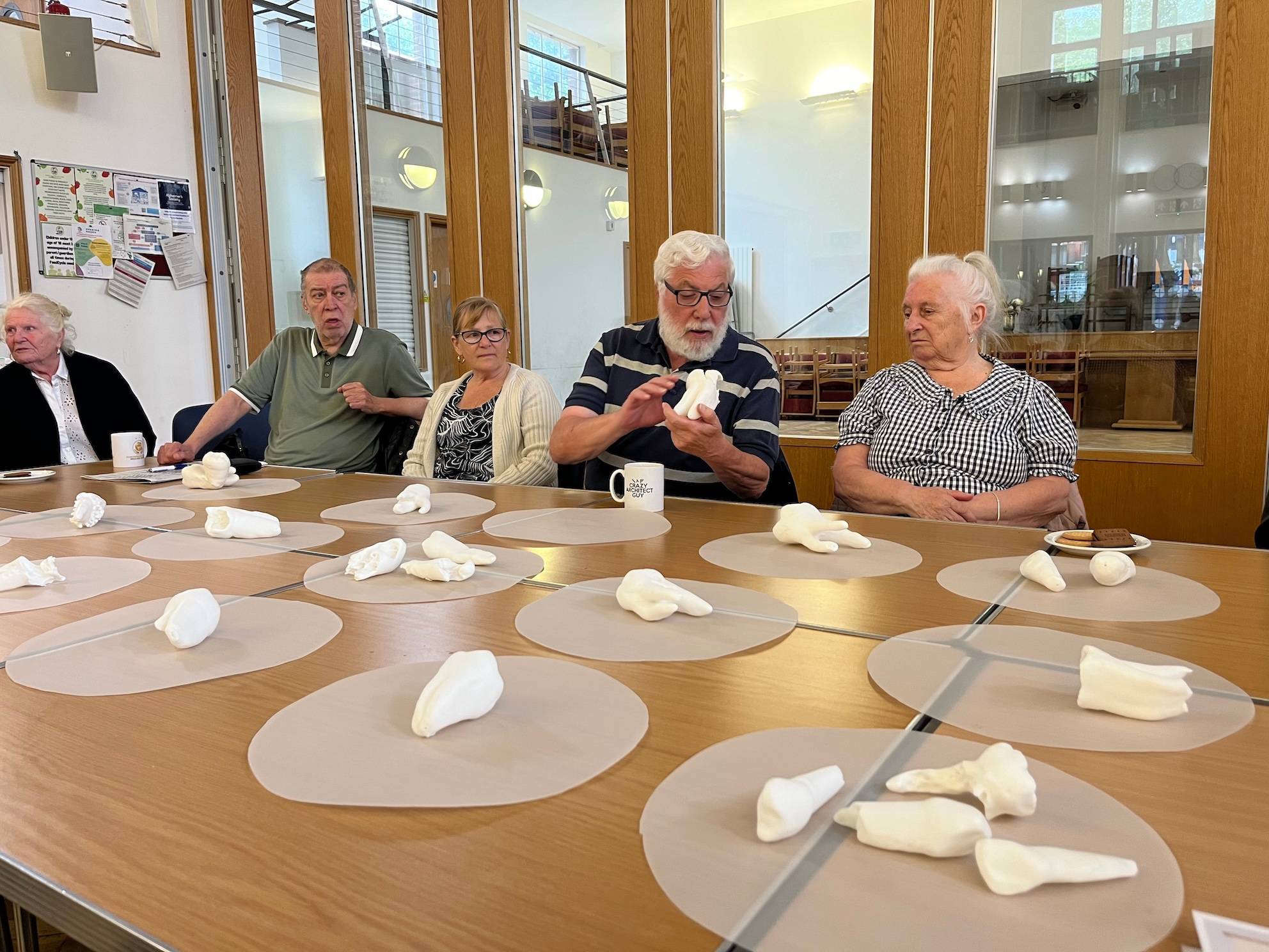 group of old people examine scultures of tooth specimens