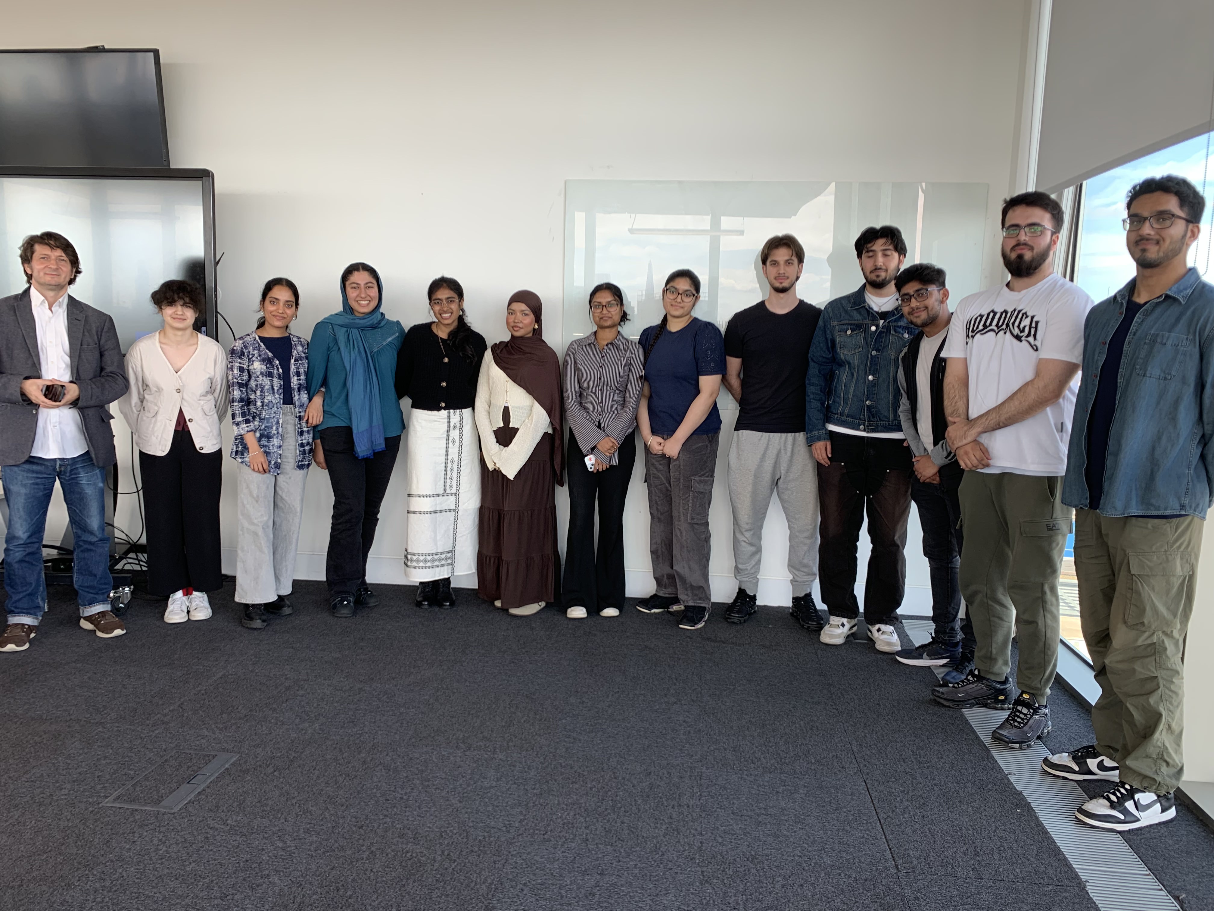 A group of students and academics facing the camera smiling