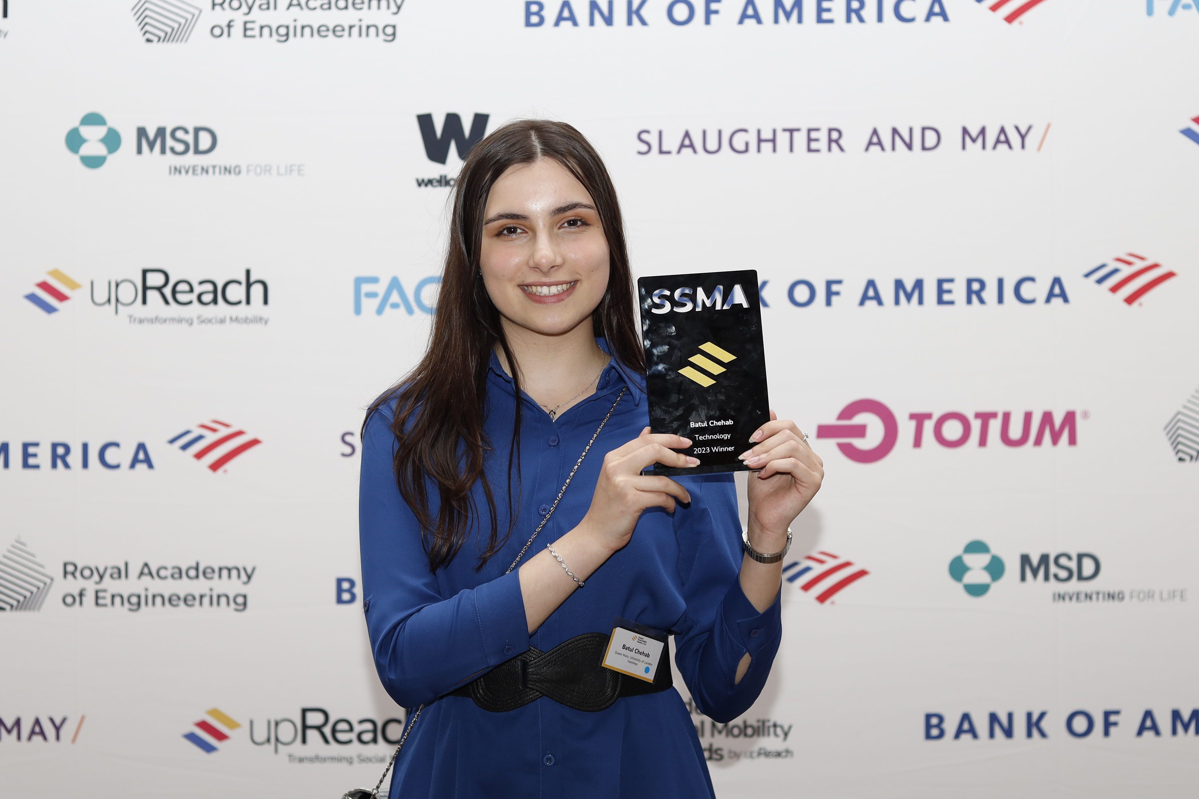 Batul facing the camera and holding award