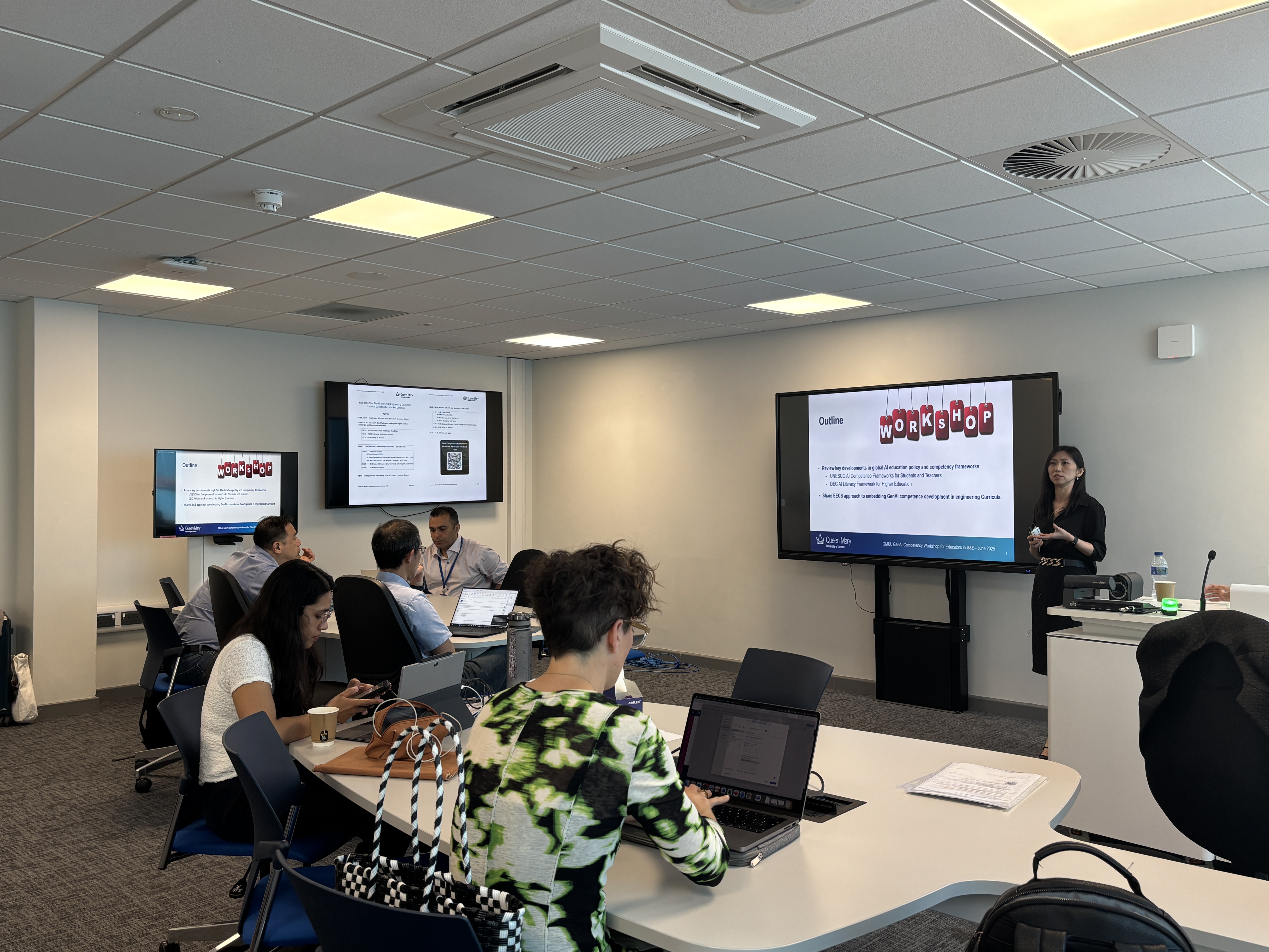Group of workshop attendees looking at screen and presenter