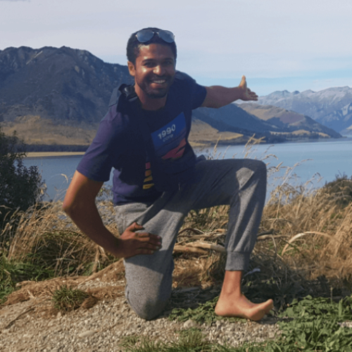 Terence pictured in front of mountains and a lake on his travels