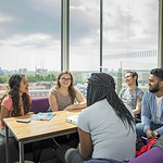 Queen Mary students in discussion sitting around a table 
