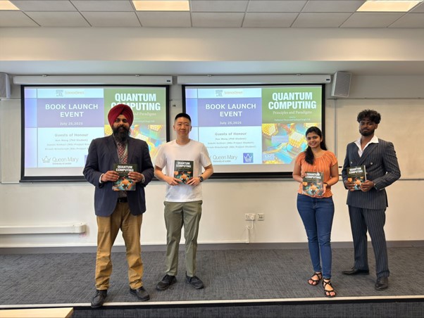 4 people on a stage holding a book at launch