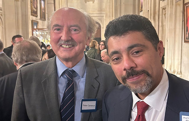 Professor Peter Cameron posing for a photo at an event with another attendee.