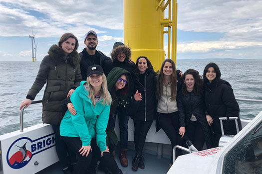 Energy law students on a boat in an ocean wind farm