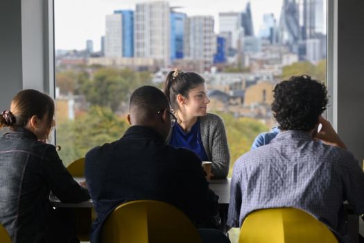 Group of international students on campus with London skyline behind