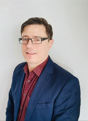 A picture of Nolan Stain in a blue suit, against a plain background