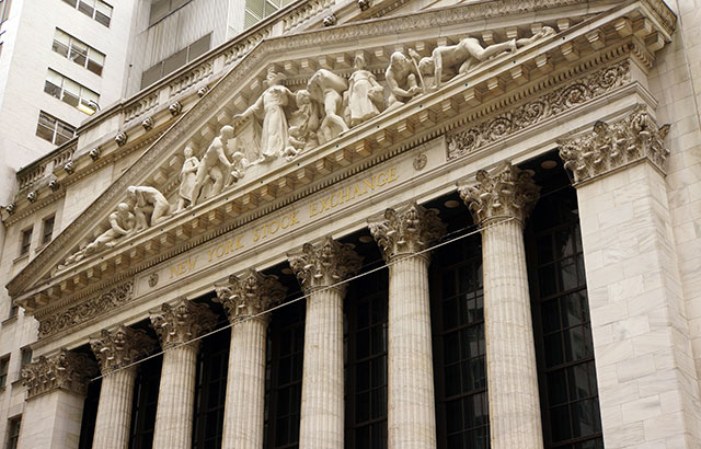 The front of the New York Stock Exchange Building. There is a frieze in the pediment, held up by Corinthian columns.There is a
