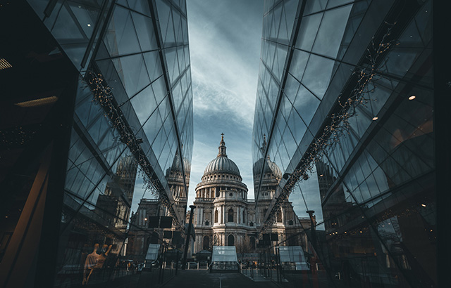 A view of St Paul's Cathedral between two glass office buildings.