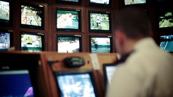 A CCTV operator in front of a series of screens monitoring Birmingham city centre