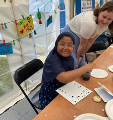 A child making artwork at the LAC's I Am You stall at the Queen Mary Festival of Communities.