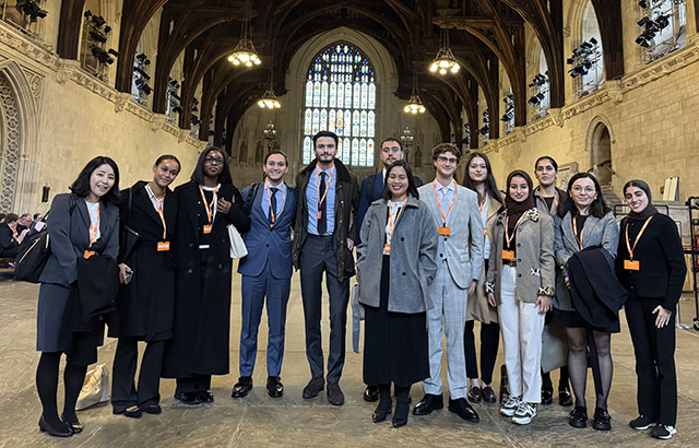 Group of Queen Mary LLM students stood in House of Lords smiling at camera