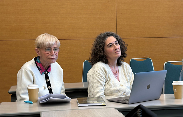Malgosia sits at a desk beside a lady with dark hair