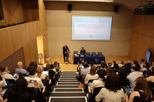 Noam Shemtov speaking at a lecture room full of people at the 2024 Queen Mary Intellectual Property Research Institute Conference.