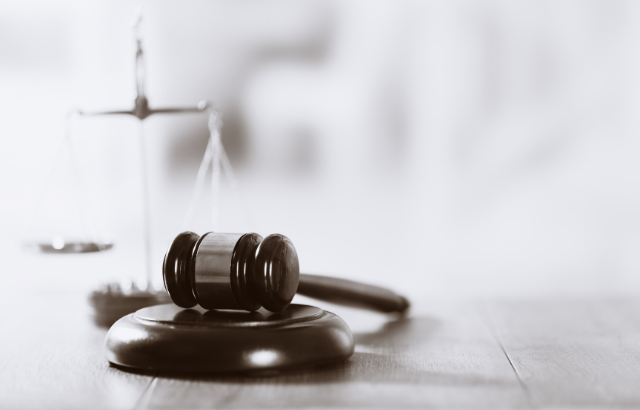 Black and white of a gavel resting on a bench