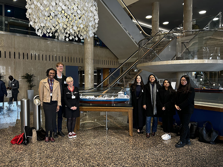 A group of students stood together in a building foyer