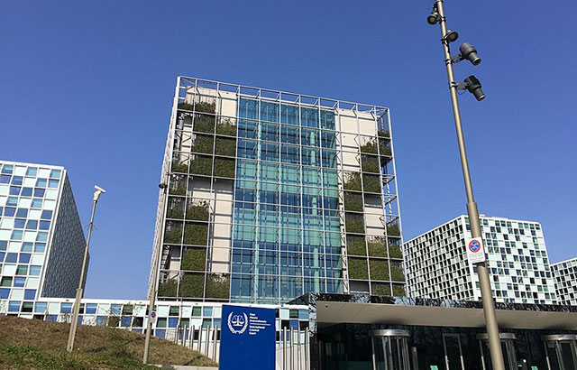 The exterior of the International Criminal Court. It's glass fronted with a living wall on either side of the building,