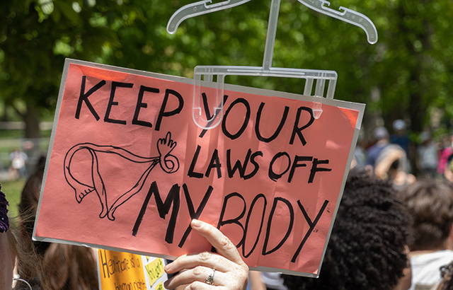 Someone holding up a sign at a protest that says 