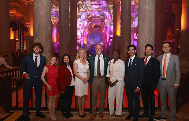 Queen Mary LLM students standing in a pillared hall at the AIEN 2025 conference.