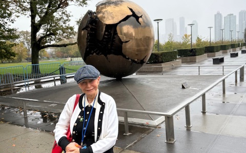 Professor Malgosia Fitzmaurice standing in front of the Sphere Within Sphere sculpture outside the UN offices in New York.