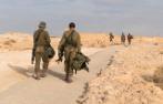 Israeli soldiers walking in the Masada desert.