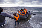 Syrian migrants / refugees arrive from Turkey on boat through sea with cold water near Molyvos, Lesbos on an overload dinghy. Leaving Syria that has war