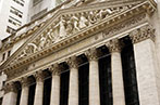 The front of the New York Stock Exchange Building. There is a frieze in the pediment, held up by Corinthian columns.There is a