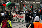 A group of protesters holding a sign saying 'STOP GENOCIDE FREE GAZA'.