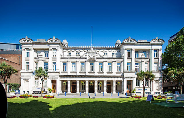 The exterior of the Queens' Building in the sunshine.